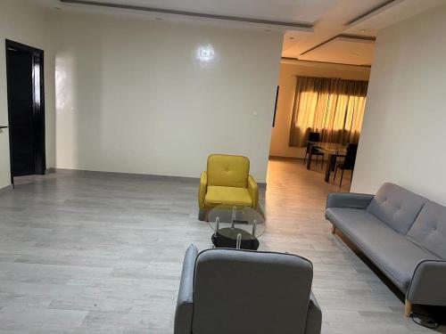 a waiting room with two couches and a yellow chair at Keeluxe Cite Keur Gorgui- Superbe appartement in Dakar