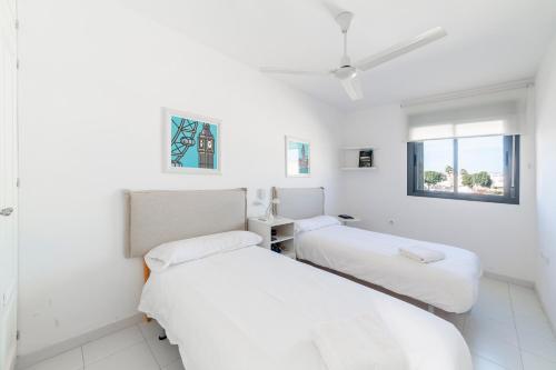 2 camas en una habitación con paredes blancas en Casa Minuni, en Almería