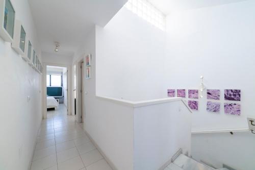 un pasillo con paredes blancas y suelo de baldosa blanca en Casa Minuni, en Almería