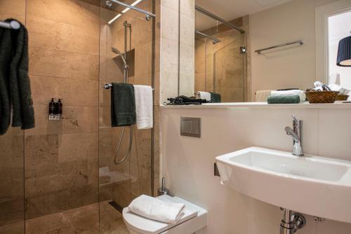 ein Bad mit einer Dusche, einem Waschbecken und einem WC in der Unterkunft Palma Suites in Palma de Mallorca