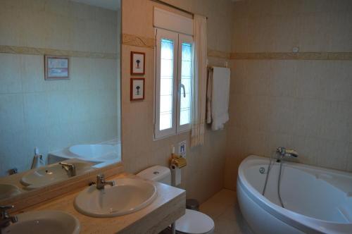 y baño con 2 lavabos, bañera y aseo. en Chalet AIRAM en Monachil
