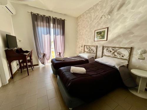 una habitación de hotel con 2 camas y un piano en Ares Hotel, en San Giovanni la Punta