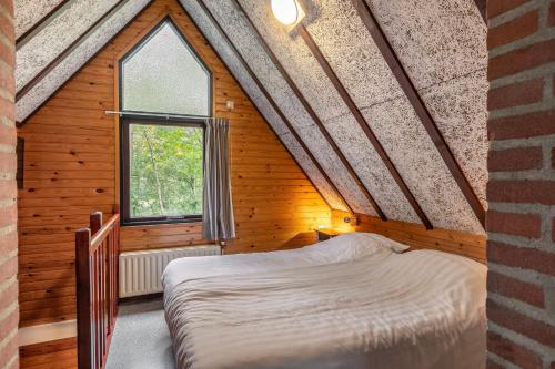 Un dormitorio con una cama en una casa de madera. en Summio Vakantiepark Herperduin, en Herpen