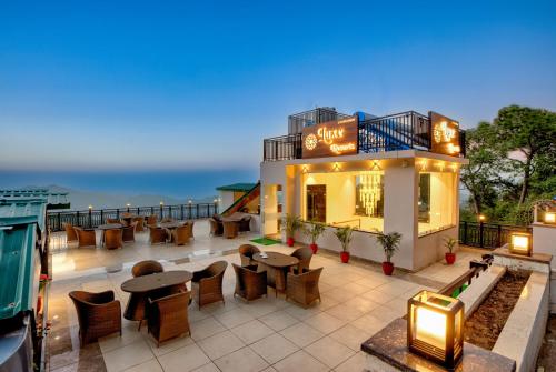 een restaurant met tafels en stoelen op een patio bij LUXE RESORTS - CENTRALLY HEATED AIR CONDITIONED HOTEL in THE HEART OF KASAULI in Kasauli