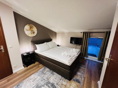 een slaapkamer met een bed en een klok aan de muur bij Hotel Garni BALTICpetite in Heringsdorf