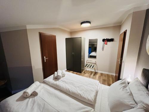een slaapkamer met 2 bedden en witte lakens bij Hotel Garni BALTICpetite in Heringsdorf