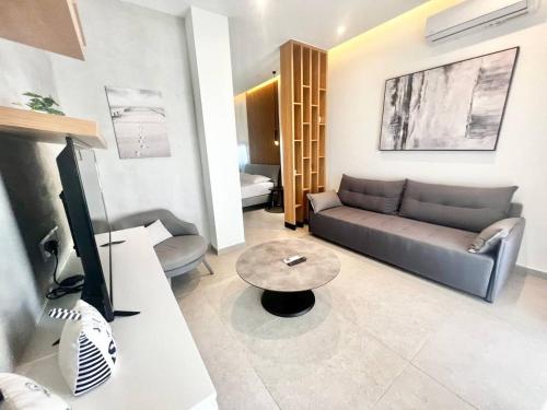 Una sala de estar con un sofá y un televisor. en Crystal-Blue-Villa Protaras, en Protaras