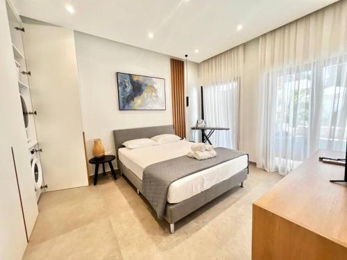 Un dormitorio con una cama y una ventana grande. en Crystal-Blue-Villa Protaras, en Protaras