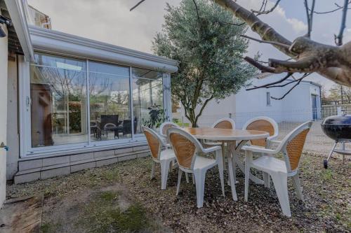 une table et des chaises devant une maison dans l'établissement Charmante maison au calme Royan, à Royan