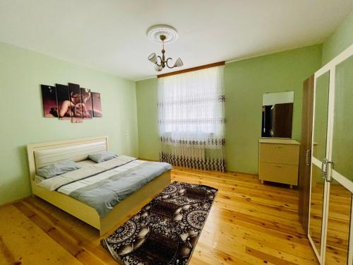 een slaapkamer met groene muren, een bed en een raam bij AkbA-Frame2 in İsmayıllı
