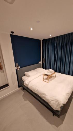 Schlafzimmer mit einem großen Bett mit blauem Kopfteil in der Unterkunft Het Huis Met De Groene Deur in Amsterdam