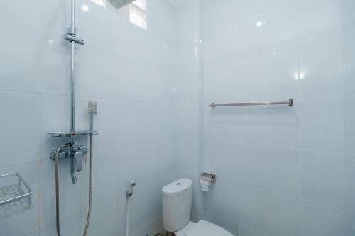 a white bathroom with a shower and a toilet at Urbanview keTemon Hotel & Resto YIA by RedDoorz in Yogyakarta