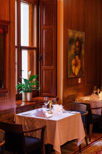 a dining room with a table and chairs and a window at Schloss Fellin Boutique Hotel and Spa in Viljandi