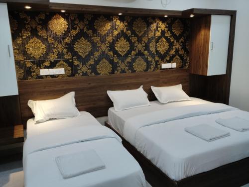 2 Betten nebeneinander in einem Zimmer in der Unterkunft SR RESIDENCY in Chennai