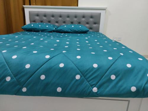 a bed with a blue comforter with white polka dots at PRIVATE ROOM FOR BUSINESS EXECUTIVES BY MAUON TOURISM in Dubai