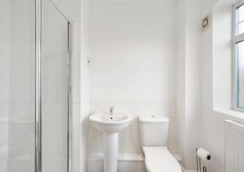 ein weißes Bad mit einem WC und einem Waschbecken in der Unterkunft 4 Bedroom Apartment with non-smoking room, great location, free Wi-Fi & Parking - Big monthly price reduction in Lincolnshire