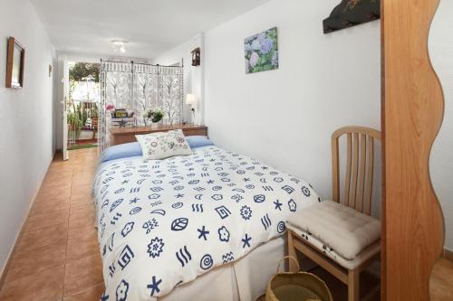 a bedroom with a bed with a blue and white comforter at Villa Jacaranda in Cala del Moral