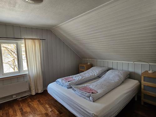 a bedroom with a bed in a room with a window at At The Lakeside II in Skulestadmo