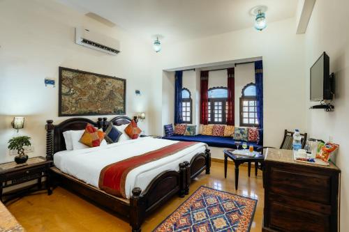 ein Schlafzimmer mit einem großen Bett und einem Sofa in der Unterkunft Hotel The Golden House in Jaisalmer