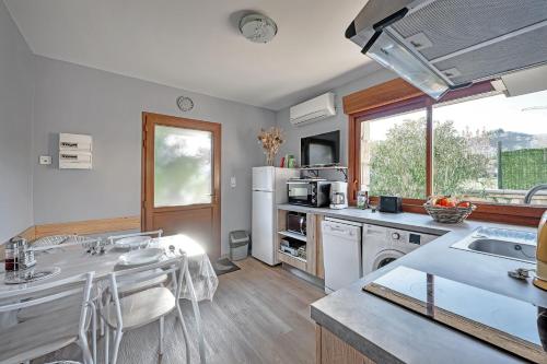 une cuisine avec des appareils blancs et une grande fenêtre dans l'établissement La Fontaulière - Vue montagne et parking privé, à Meyras