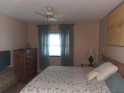 4080 Lake Bayshore Drive في برادنتون: غرفة نوم بسرير وتلفزيون ونافذة