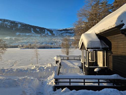a house covered in snow next to a snow covered field at Voss Interlake in Skulestadmo