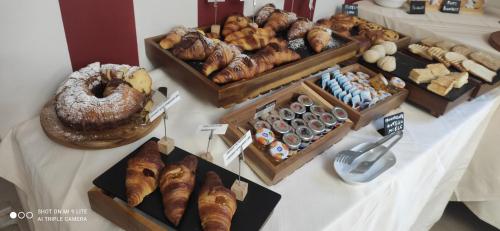 una mesa con diferentes tipos de bollería y pan en Palazzo Marignano Hotel, en Melegnano