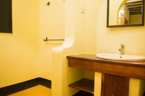 a bathroom with a sink and a mirror at Fort Murchison Lodge by NATURE LODGES LTD in Pakwach East