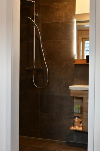 a shower with a hose in a bathroom at Übernachtung beim Bio-Metzger Zimmer "Karl" in Mössingen