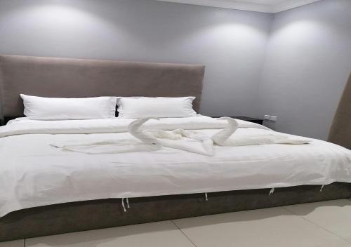 łóżko z dwoma białymi ręcznikami w obiekcie DORRA ABHUR w mieście Obhor