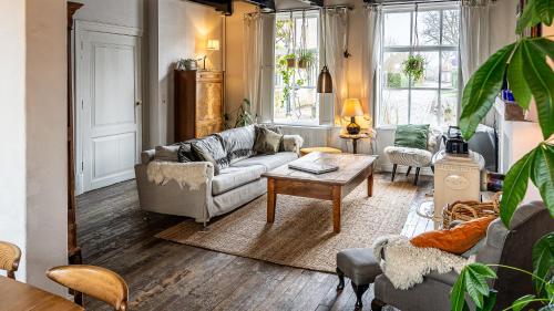ein Wohnzimmer mit einem Sofa und einem Tisch in der Unterkunft Haven 1 in Sint Anna ter Muiden