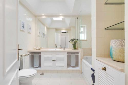 a bathroom with a sink and a toilet and a mirror at Unique beach Villa with ocean view pool tennis in Cascais