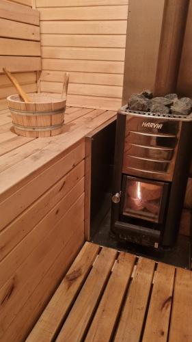 a woodburning stove in a sauna with a basket at Tiny House Flexhome in Buchenberg