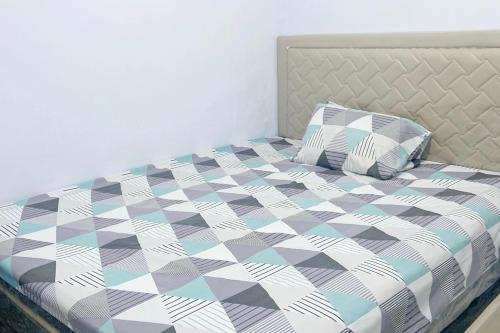 um quarto com uma cama com um cobertor e almofadas xadrez em Pondokan Guest House Rinjani Syariah em Bengkulu