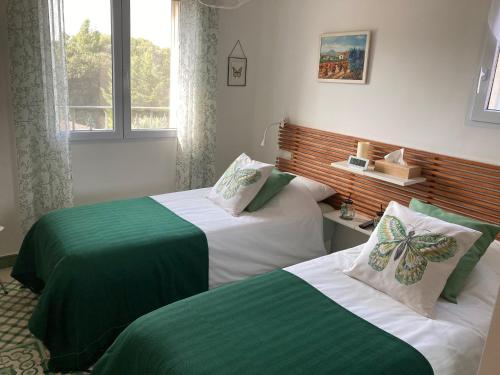 1 dormitorio con 2 camas con sábanas verdes y blancas en Domaine des Lavarines, en Morières-lès-Avignon