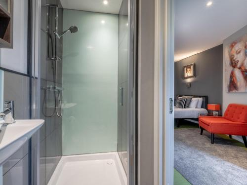 a bathroom with a shower and a red chair at 9 Bed in Woolverstone 62352 in Freston