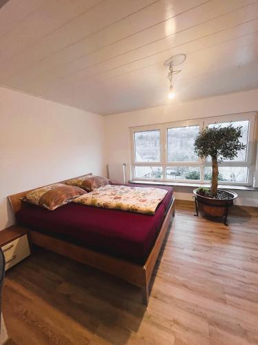 um quarto com uma cama e uma árvore em Frisch renovierte Ferienwohnung in ruhiger Lage em Braunfels