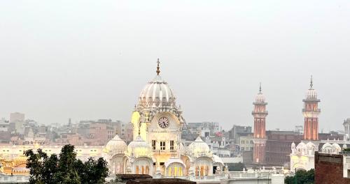 um edifício com uma torre de relógio em cima em Hotel Heaven View - 50m From Golden Temple em Amritsar