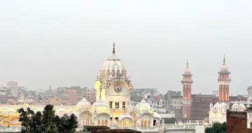 ein Gebäude mit einem Uhrturm darüber in der Unterkunft Hotel Heaven View - 50m From Golden Temple in Amritsar