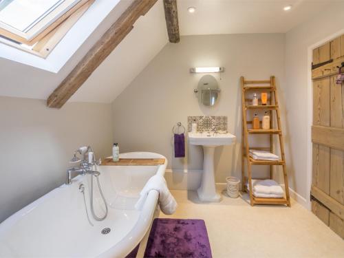 a bathroom with a bath tub and a sink at 3 Bed in North Creake KT033 in North Creake