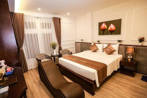 een hotelkamer met een groot bed en een bureau bij Sen Hotel - Số 23, ngõ 1, Lê Văn Thiêm - by Bay Luxury in Hanoi