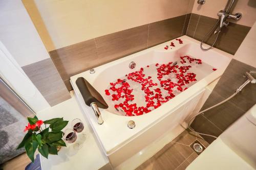 een badkamer met een bad gevuld met rode bloemen bij Sen Hotel - Số 23, ngõ 1, Lê Văn Thiêm - by Bay Luxury in Hanoi