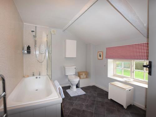 a white bathroom with a tub and a toilet at 3 Bed in Kettlestone KT037 in Little Snoring