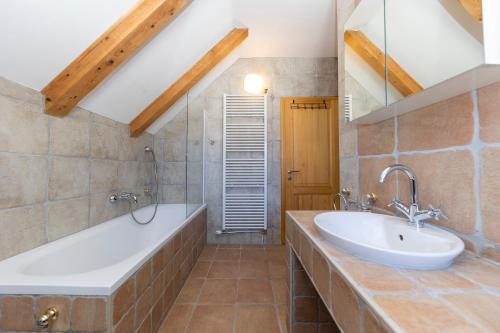 uma casa de banho com uma banheira grande e um lavatório em SPA HOLIDAY HOUSE REŽEK - Lovinac em Lovinac