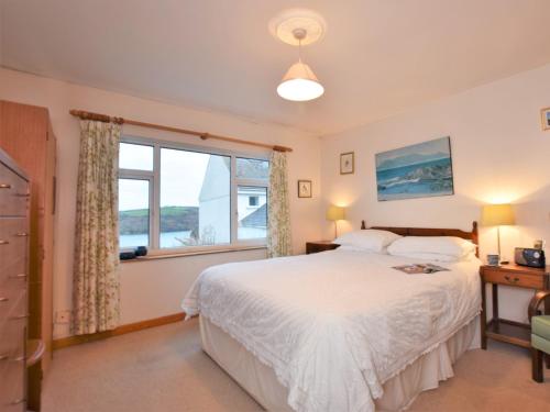 a bedroom with a bed and a window at 3 Bed in Polruan PC052 in Polruan