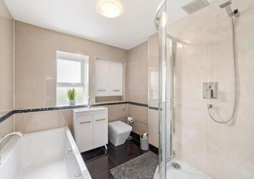y baño con bañera, aseo y ducha. en 3 Bedroom House, great location, family & business trip en North Hykeham
