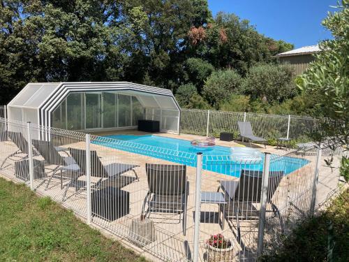 une clôture avec des chaises et une piscine dans l'établissement Domaine des Lavarines, à Morières-lès-Avignon