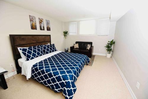a bedroom with a blue and white bed and a chair at Adorable Spacious Inn with Indoor fireplace in Kingston