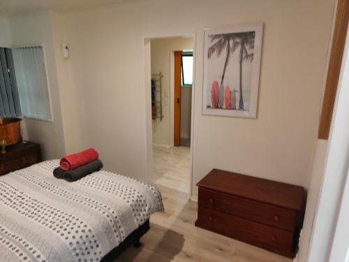 a bedroom with a bed and a dresser and a mirror at Harbourside Haven in Ohope Beach