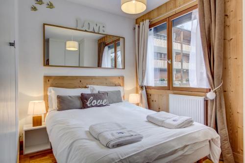 a bedroom with a bed with two towels on it at Minuit Apartment - Snow and Trek - Morzine in Morzine